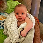 Hayes joined the competition — help win amazing prizes! baby, blanket, child, person, adult, beard, green_shirt, couch, arm, hand, indoor, comfort, cute, wrapped, snug, expression, wide_eyes, soft_texture, portrait, warmth