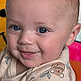 Hayes is registered to the contest to win money with this photo: baby, child, smiling, blue_eyes, face, infant, cute, clothing, patterned_outfit, baby_seat, colorful, playful, cartoon_background, close_up, happy, tongue_out, skin, head, young, indoors