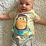Hayes is registered to the contest to win money with this photo: baby, child, infant, smiling, lying_down, buzz_lightyear, tshirt, shorts, barefoot, rug, floor, happy, cute, indoor, person, apparel, portrait, face, head, young_child