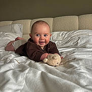 Léo a rejoint le concours — aidez-le/la à gagner de superbes lots ! baby, infant, smiling, bed, blanket, teddy_bear, toy, indoor, cute, child, happy, face, clothing, lying_down, pillow, cozy, home, portrait, young, comfort