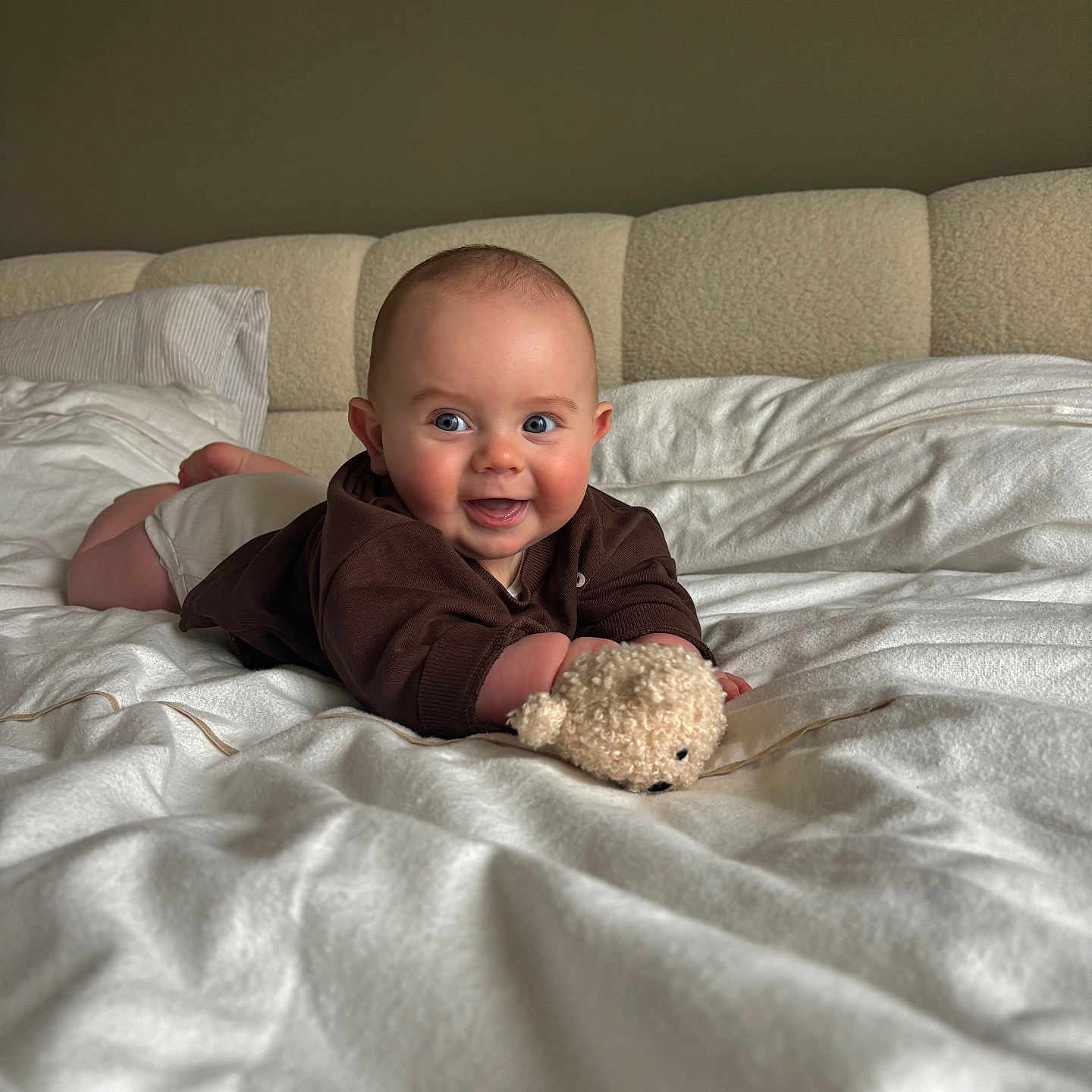 Léo a rejoint le concours — aidez-le/la à gagner de superbes lots ! baby, infant, smiling, bed, blanket, teddy_bear, toy, indoor, cute, child, happy, face, clothing, lying_down, pillow, cozy, home, portrait, young, comfort