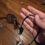Sora is registered to the contest to win money with this photo: cat, tabby_cat, hand, chewed_cable, usb_cable, tiny_fan, hardwood_floor, shoe, sock, cat_toy, indoor, pet, floorboards, fingers, thumbnail, claw_marks, cord, living_space, curiosity, playtime