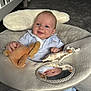 Theo is registered to the contest to win money with this photo: baby, infant, plush_toy, giraffe_toy, mirror, baby_seat, carpet, crib, smiling, blue_clothing, indoor, child, reflection, soft_toy, cute, happy, person, cushion, room, floor