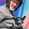 man, dog, helmet, motorcycle_gear, glasses, jacket, pet, outdoor, portrait, smiling, leather, biker, costume, cute, animal, person, fashion, fun, travel, vehicle