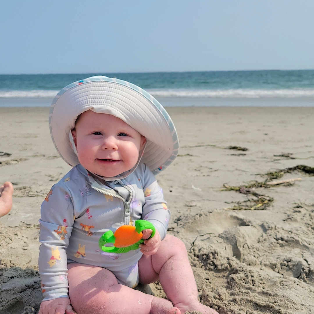 Oonagh is registered to the contest to win money with this photo: baby, beach, child, cute, happy, infant, ocean, outdoor, playful, sand, sea, sitting, sky, smiling, summer, sun_hat, sunny, swimsuit, toy, water