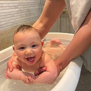 Léon participe au concours pour gagner de l'argent avec cette photo : baby, bathtub, bath, water, smile, happy, child, person, skin, arm, hand, indoor, plumbing, support, splash, joy, young, cute, fun, parent