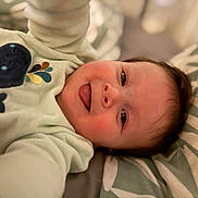ànton participe au concours pour gagner de l'argent avec cette photo : baby, baby_garment, child, closeup, clothing, cozy, cute, expression, face, happy, indoors, infant, lying_down, pattern, pillow, portrait, smiling, soft_light, tongue_out, whale_design