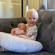 Gwenevere is registered to the contest to win money with this photo: baby, toddler, child, smiling, hugging, couch, pillow, indoor, blonde_hair, sleeping, happy, person, cozy, blanket, clothing, curtain, door, furniture, portrait, family