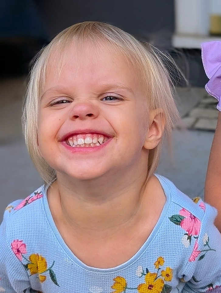 Gwenevere joined the competition — help win amazing prizes! toddler, child, smile, happy, face, blond_hair, teeth, blue_clothing, floral_pattern, portrait, closeup, cute, joy, outdoor, person, skin, expression, young, head, hair