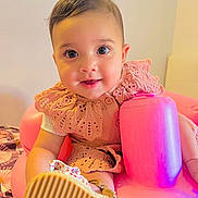 Emma a rejoint le concours — aidez-le/la à gagner de superbes lots ! baby, child, infant, pink, inflatable_seat, shoe, smile, face, cute, clothing, lace, footwear, indoor, portrait, happy, person, young_child, sitting, playful, bright