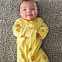 Marlee is registered to the contest to win money with this photo: baby, infant, yellow_onesie, carpet, smiling, lying_down, child, cute, comfortable, indoors, soft_texture, orange_prints, footed_pajamas, young_child, portrait, adorable, baby_clothing, relaxed, small_hands, happy