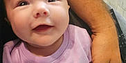 Marlee joined the competition — help win amazing prizes! baby, child, smile, purple_shirt, text_on_clothing, adult_arm, hand_holding, chair, floor, tiled_floor, indoor, person, cute, happy, infant, sitting, skin, casual_clothing, portrait, closeup