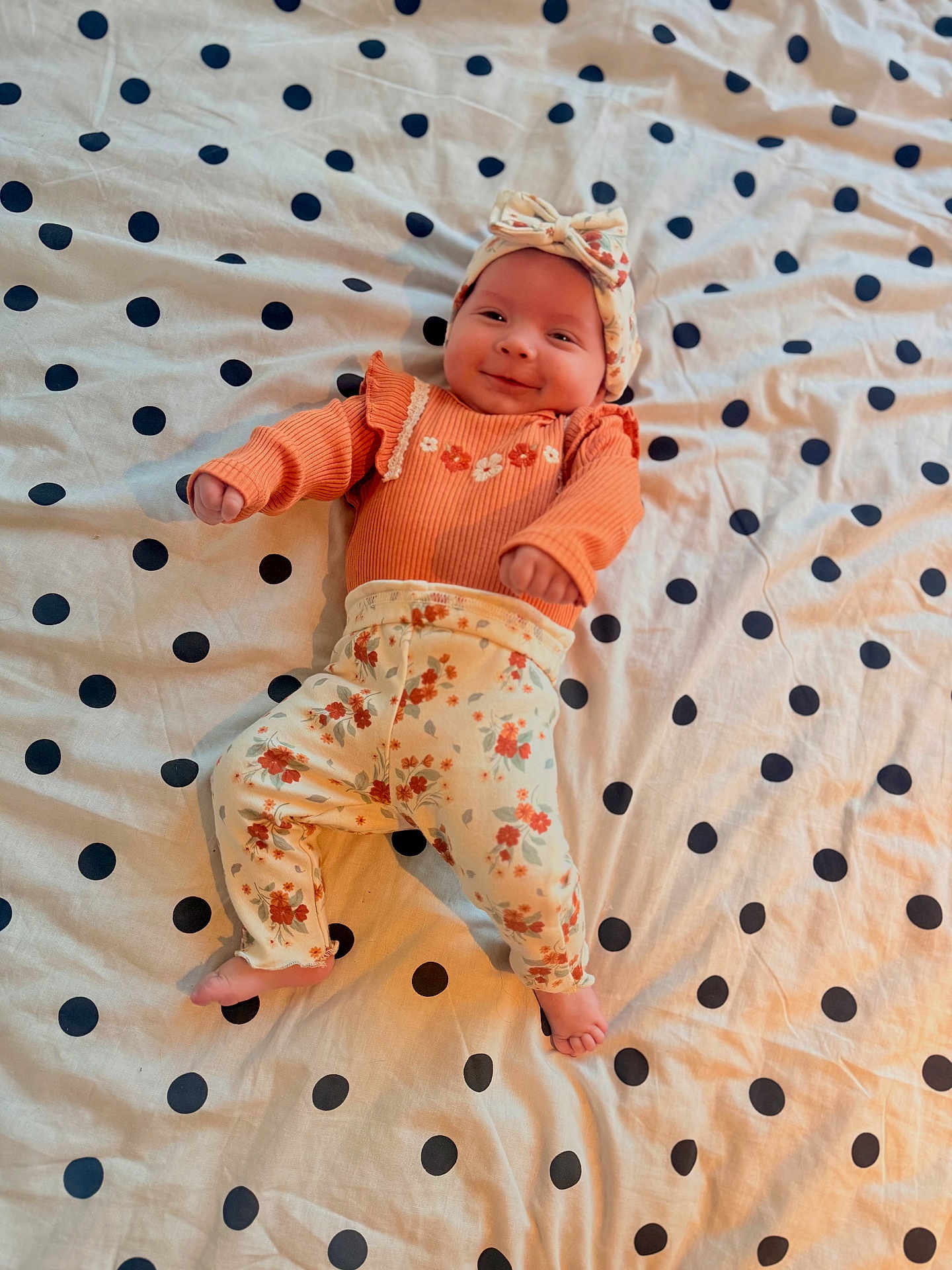Hazel joined the competition — help win amazing prizes! baby, infant, smiling, headband, floral, polka_dot, bedspread, clothing, cute, lying_down, pattern, happy, child, person, indoors, fabric, soft, small_feet, portrait, casual