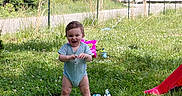 Jaxson is registered to the contest to win money with this photo: baby, grass, outdoor, balloon, birthday, towel, toy, child, greenery, summer, play, happy, smile, standing, nature, daylight, clothing, fence, house, slide