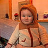 toddler, child, baby, hooded_jacket, fleece, indoor, person, face, blue_eyes, curious, warm_clothing, hand, adult_hand, wooden_beams, background, plastic_container, shelf, household_items, portrait, cozy
