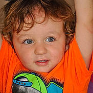 Noah is registered to the contest to win money with this photo: toddler, child, curly_hair, blue_eyes, orange_shirt, graphic_tshirt, chimpanzee, hat, patterned_hat, raising_arms, indoor, portrait, cute, happy, smiling, close_up, face, expression, casual_clothing, playful
