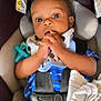 Andreus is registered to the contest to win money with this photo: baby, infant, car_seat, blue_clothing, bib, mickey_mouse, pacifier, blanket, straps, child, hands, face, wide_eyes, seat_belt, indoor, cute, person, young_child, expression, comfort