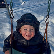 Luca is registered to the contest to win money with this photo: toddler, child, swing, winter, snow, coat, jacket, outdoor, playground, happy, smile, baby, cold, play, fun, green, seat, sunlight, park, clothing