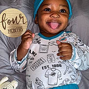 Ellias joined the competition — help win amazing prizes! baby, infant, smiling, tongue_out, hat, onesie, blue_clothing, blanket, toy, knitted_toy, wooden_sign, four_months, lying_down, cute, happy, indoor, portrait, child, miami_dolphins, face