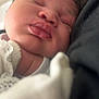 Arie-Rae is registered to the contest to win money with this photo: baby, sleeping, close_up, face, curly_hair, soft_focus, white_clothing, couch, skin, peaceful, newborn, infant, child, portrait, chubby_cheeks, resting, cozy, soft_texture, indoor, warm_lighting