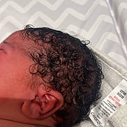 Arie-Rae joined the competition — help win amazing prizes! newborn, baby, infant, curly_hair, head, ear, skin, blanket, pattern, fabric, clothing_tag, closeup, sleeping, child, young, soft_skin, resting, indoors, portrait, human