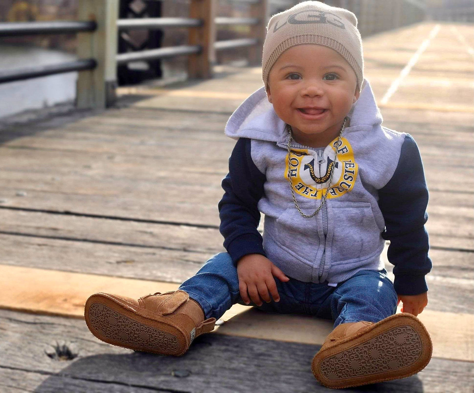 Daylen is registered to the contest to win money with this photo: baby, baby_toddler_clothing, bonnet, brown, child, cool, denim, headwear, hood, jacket, joy, outdoor_shoe, person, sitting, street_fashion, tan, toddler, walking_shoe