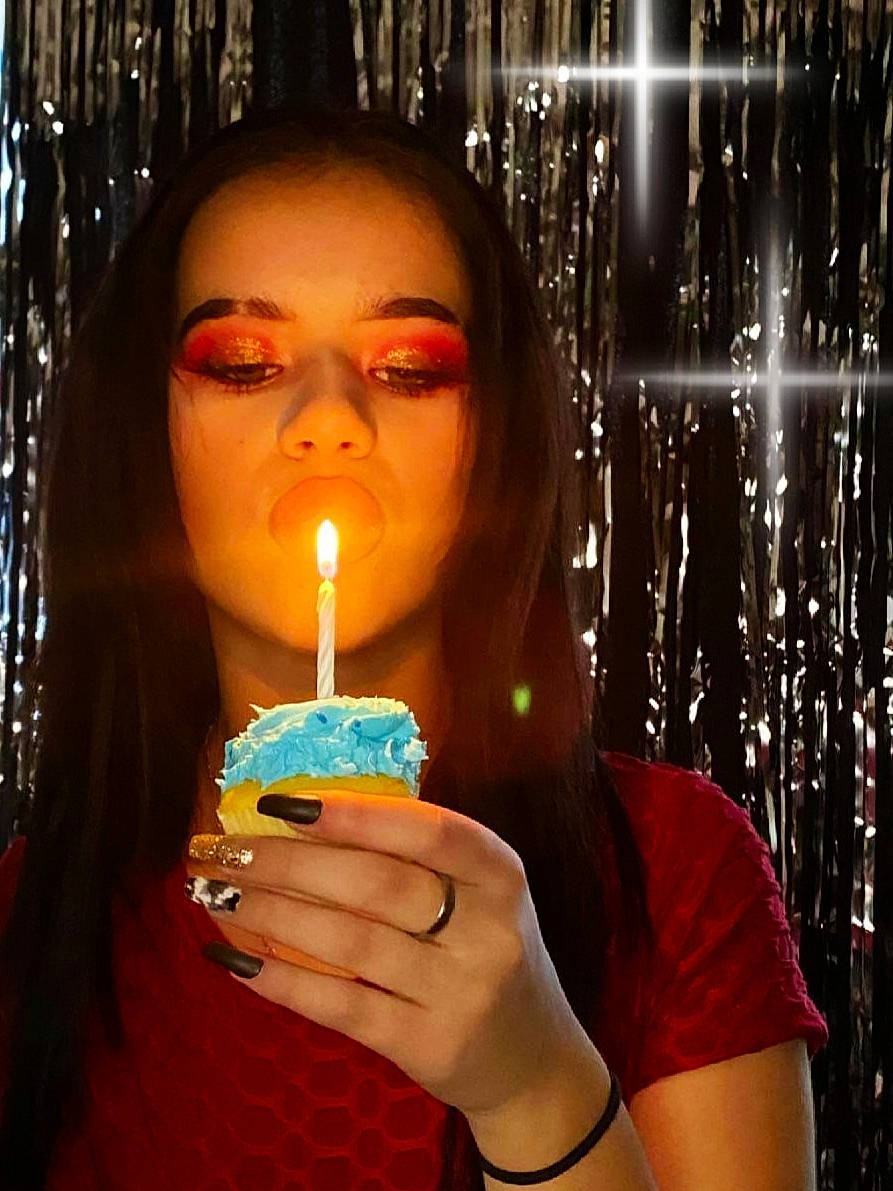 Madisen is registered to the contest to win money with this photo: black_hair, candle, cool, event, eyelash, eyewear, finger, flame, flash_photography, fun, hand, happy, jewellery, light, lighting, lip, long_hair, nail, neck, person