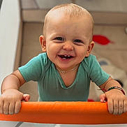 Andréa a rejoint le concours — aidez-le/la à gagner de superbes lots ! baby, child, smiling, playpen, onesie, bracelet, indoor, happy, cute, holding, face, teeth, person, infant, looking_at_camera, short_hair, home, toy, floor, colorful