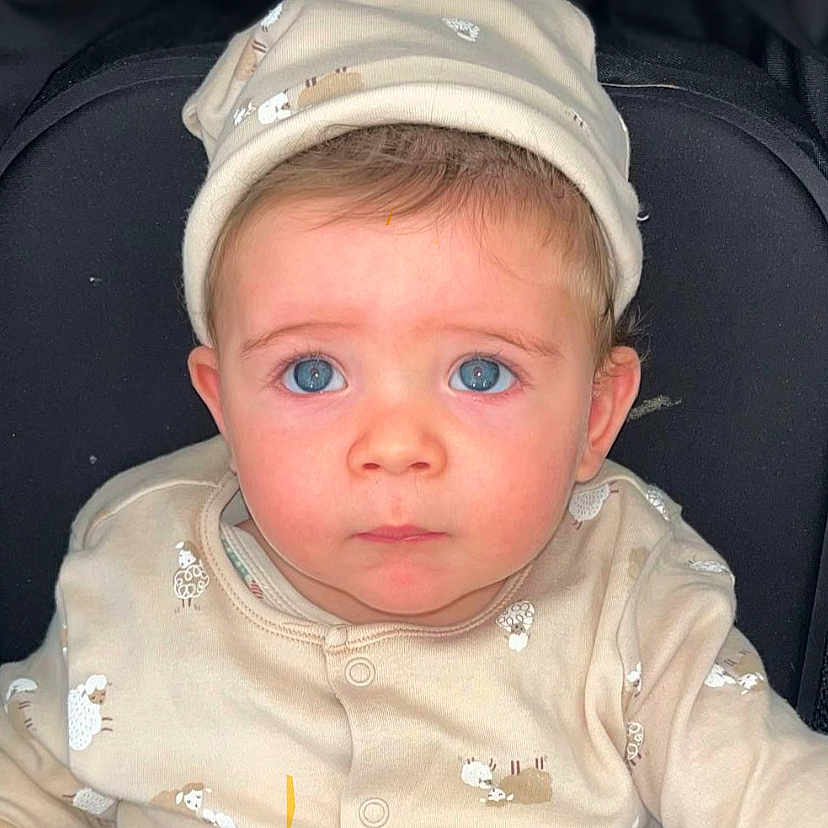 Zaïn a rejoint le concours — aidez-le/la à gagner de superbes lots ! adorable, baby, beige_clothing, blue_eyes, buttoned_clothing, child, closeup, cute, expression, face, hat, indoors, infant, looking_up, newborn, person, portrait, seated, soft_fabric, young