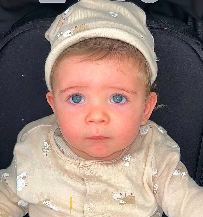 Zaïn a rejoint le concours — aidez-le/la à gagner de superbes lots ! baby, blue_eyes, beige_clothing, hat, infant, face, portrait, child, cute, looking_up, seated, adorable, young, person, newborn, soft_fabric, buttoned_clothing, closeup, indoors, expression