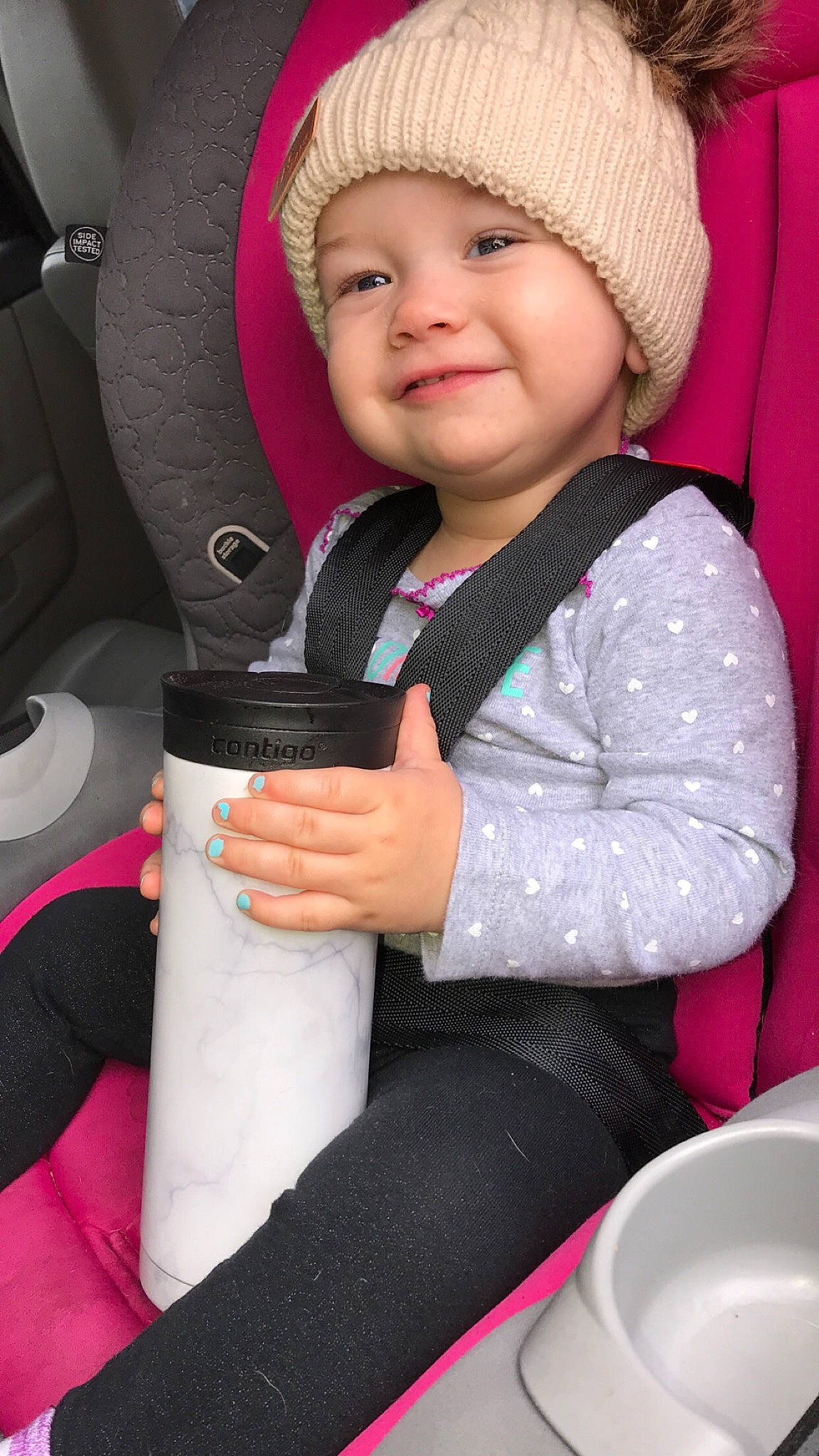 Oakley is registered to the contest to win money with this photo: auto_part, baby, baby_in_car_seat, car_seat, car_seat_cover, child, headgear, headwear, joy, person, pink, seat_belt, toddler