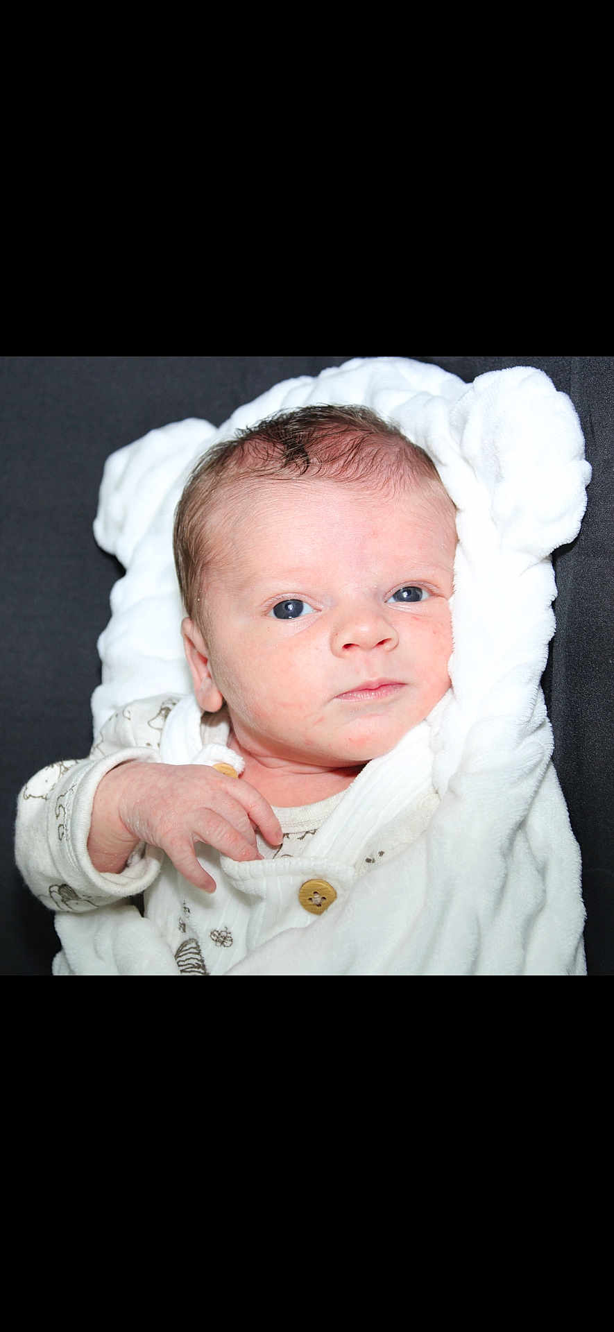 Lyssandro a rejoint le concours — aidez-le/la à gagner de superbes lots ! baby, newborn, infant, swaddled, blanket, white_blanket, face, eyes, hand, onesie, button, skin, closeup, portrait, indoor, soft_texture, expression, gaze, studio_light, cute