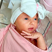 Angelika is registered to the contest to win money with this photo: baby, newborn, infant, hat, bow, swaddle, pink_blanket, hospital_blanket, hand, face, eyes, lips, portrait, closeup, cozy, crib, clothing, blanket_stripes, newborn_cap, cute