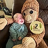 Rune is registered to the contest to win money with this photo: 2_months, baby, carpet, chair, child, cuddly, happy, home_interior, infant, leather, monkey, onesie, plush, portrait, sign, sitting, smiling, stuffed_toy, toy, wooden_sign