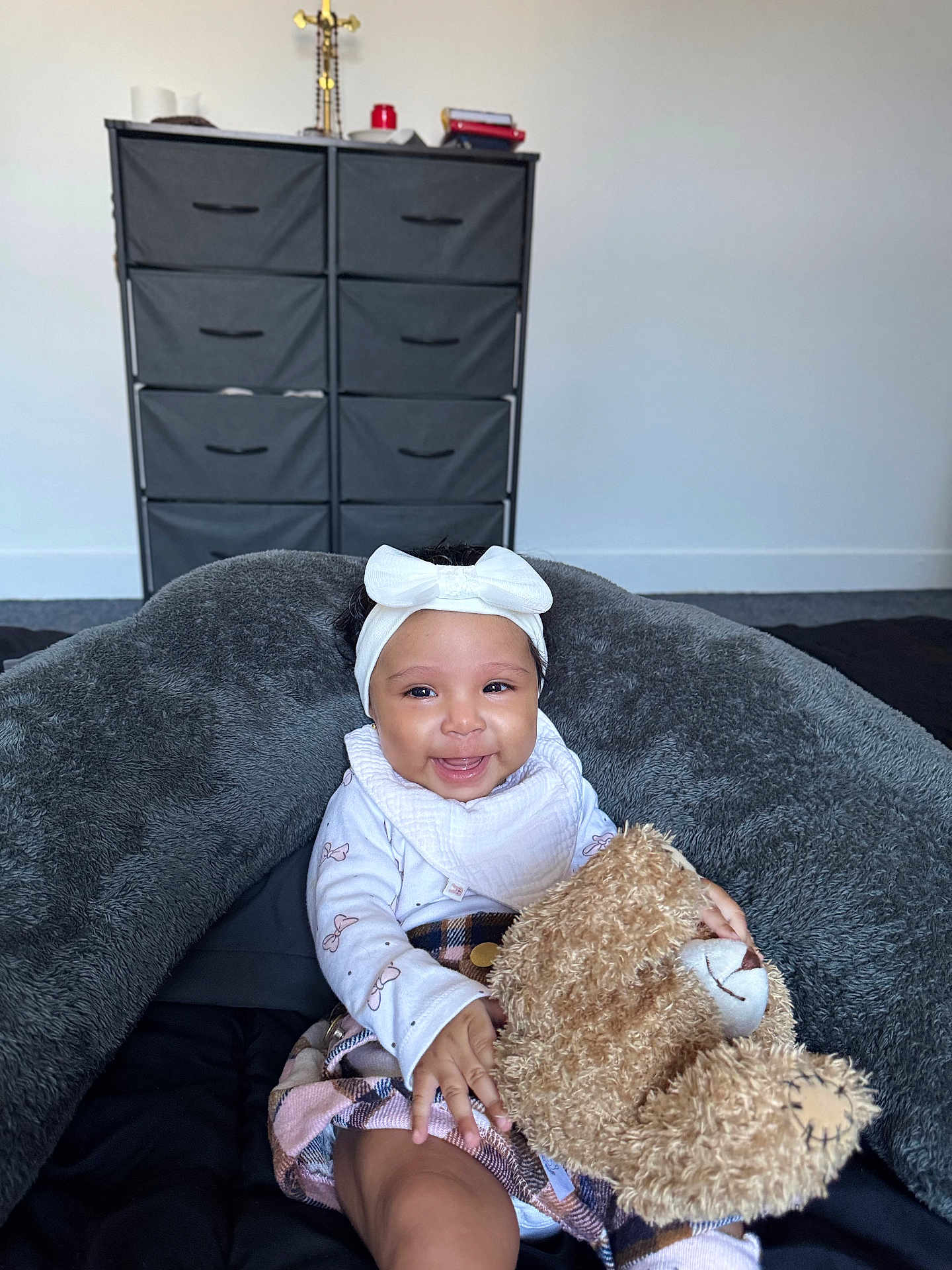 Sienna is registered to the contest to win money with this photo: baby, smiling, teddy_bear, headband, bow, blanket, cushion, infant, child, indoor, cozy, happy, person, plush_toy, clothing, sitting, portrait, furniture, room, soft