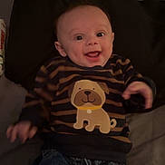 Gabriel joined the competition — help win amazing prizes! baby, child, smiling, sweater, dog_cartoon, striped_clothing, denim, jeans, pillow, bed, happy, portrait, indoor, infant, cute, young_child, clothing, person, lying_down, cheerful