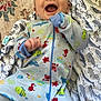 Cooper is registered to the contest to win money with this photo: baby, infant, smiling, onesie, colorful, pattern, blanket, happy, cute, face, child, clothing, playful, lying_down, indoor, soft, fabric, closeup, young_child, joyful