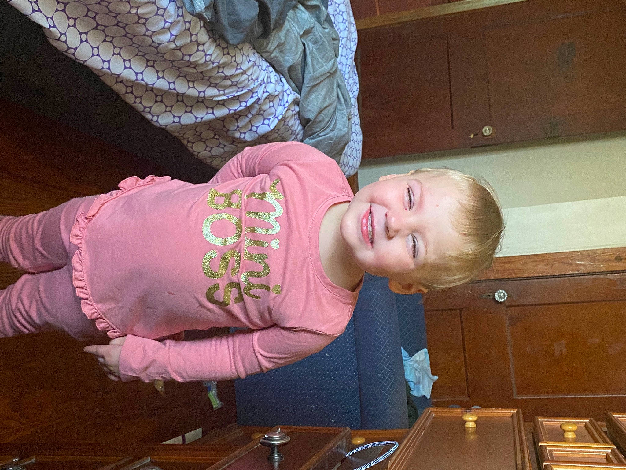 Nevaeh joined the competition — help win amazing prizes! baby_toddler_clothing, cabinetry, child, drawer, fun, hardwood, hat, joy, magenta, pattern, person, room, sitting, sleeve, smile, t_shirt, toddler, varnish, wood