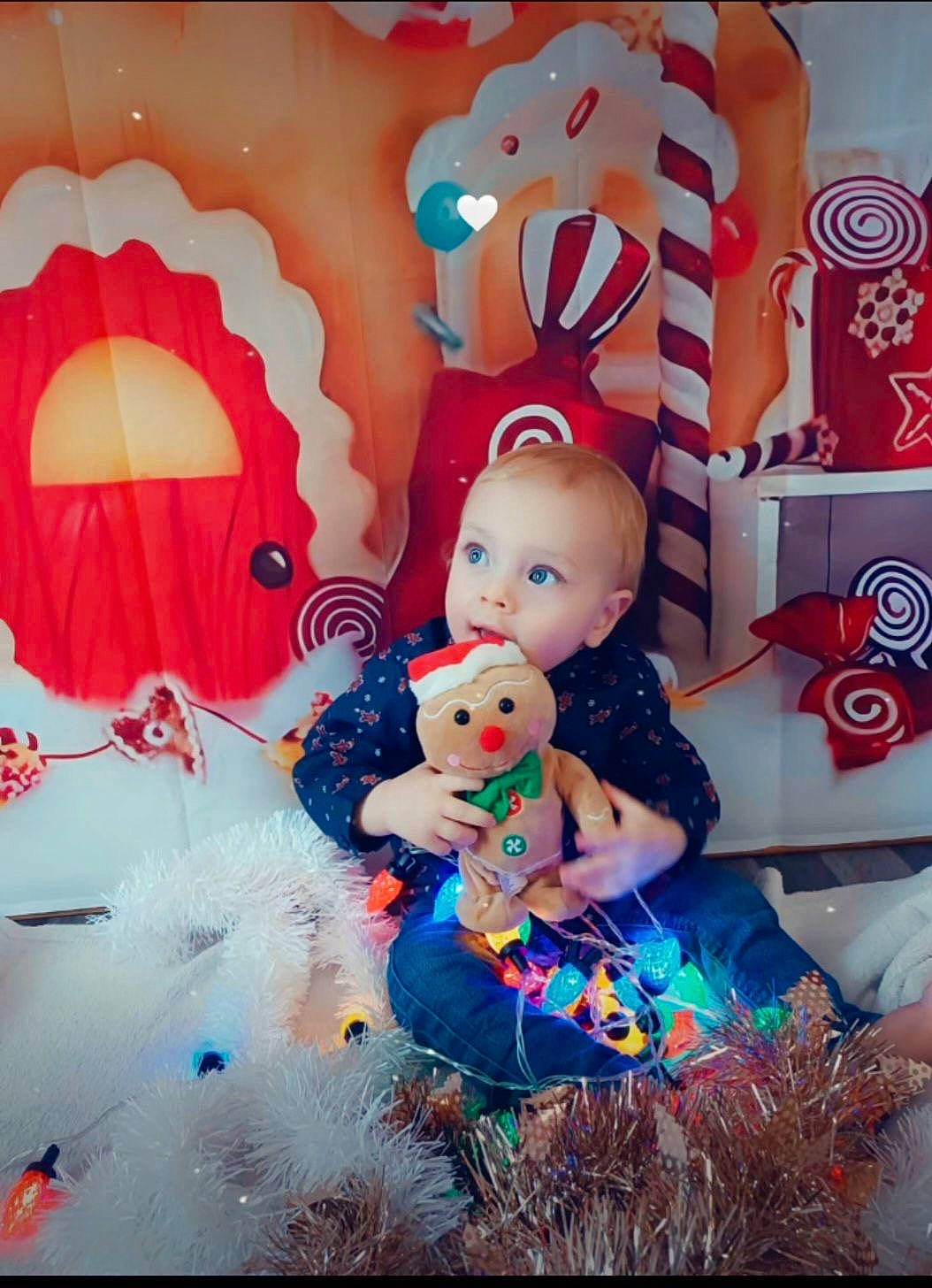 Esteban participe au concours pour gagner de l'argent avec cette photo : art, baby, baby_toddler_clothing, carmine, child, christmas, christmas_eve, christmas_ornament, doll, event, fictional_character, fun, happy, holiday, person, pink, red, room, sweetness, toddler