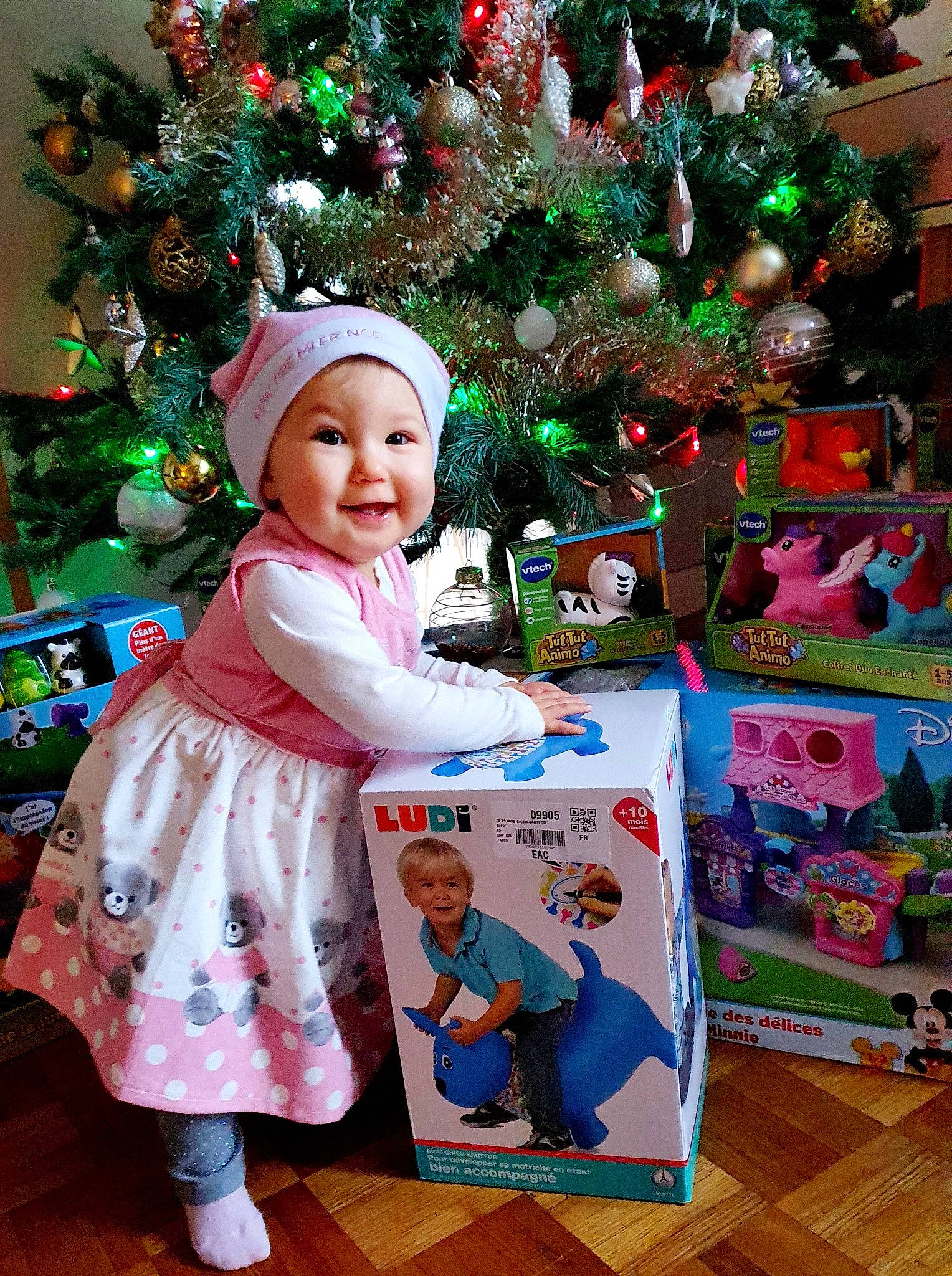 Aurore participe au concours pour gagner de l'argent avec cette photo : baby_toddler_clothing, christmas, christmas_decoration, christmas_eve, christmas_lights, christmas_ornament, christmas_tree, conifer, costume_accessory, event, fictional_character, headwear, holiday, holiday_ornament, interior_design, joy, laugh, ornament, person, pine_family