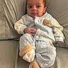 Josiah is registered to the contest to win money with this photo: baby, infant, child, portrait, lying_down, couch, cushion, pajamas, quilted_clothing, blue_clothing, bear_design, stuffed_bear, socks, fuzzy_socks, face, eyes, indoors, home, cute, photography