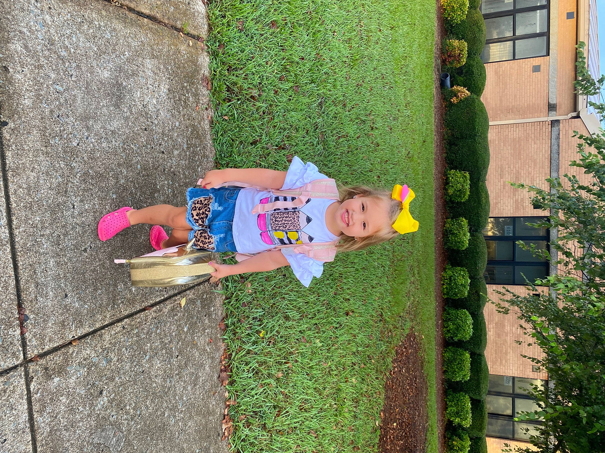 Kendall is registered to the contest to win money with this photo: baby_toddler_clothing, child, fun, garden, grass, green, hat, joy, leaf, leisure, people_in_nature, person, plant, recreation, shrub, sidewalk, smile, t_shirt, toddler, tree