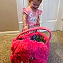 toddler, child, pink_dress, bow, hair_accessory, smiling, indoor, carpet, door, toy_bag, fuzzy, plush, happy, person, cute, small_child, playful, colorful, clothing, floor