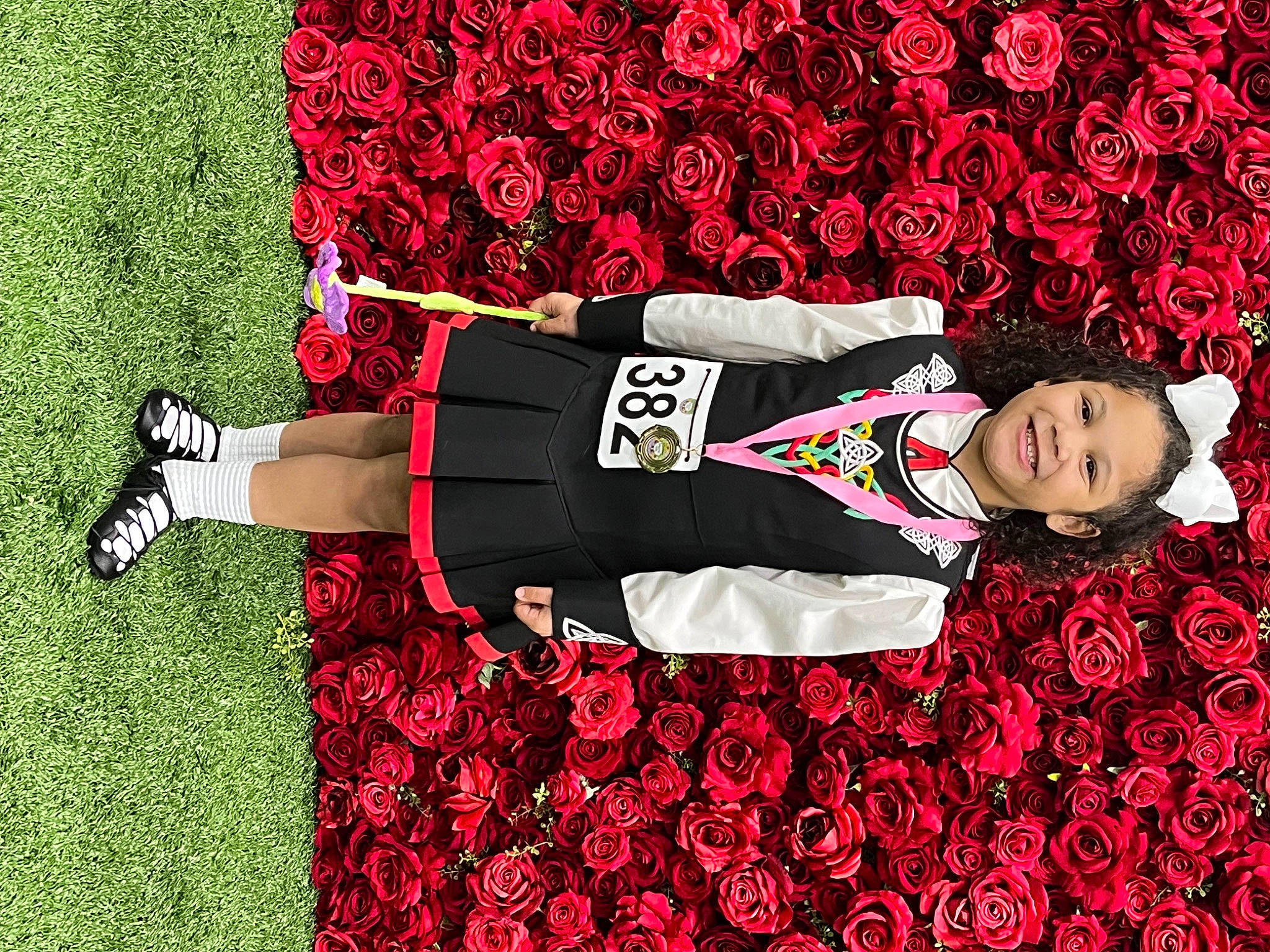 Kierra is registered to the contest to win money with this photo: carmine, clothing, event, fashion_design, flooring, flower, font, grass, happy, human_leg, joy, knee, magenta, pattern, person, petal, pink, plant, red, sleeve