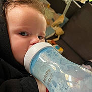 Théo a rejoint le concours — aidez-le/la à gagner de superbes lots ! toddler, child, baby_bottle, foam, philips_avent, black_hoodie, indoor, face, hand, curly_hair, couch, toy, window, living_room, person, close_up, hydration, young_child, casual_wear, bottle_feeding