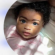 Avalee joined the competition — help win amazing prizes! baby, infant, face, curly_hair, eyes, pink_clothing, portrait, close_up, natural_light, shadow, circle_frame, phone_screen, digital_overlay, child, looking_up, expression, soft_texture, skin, cute, young