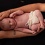 newborn, baby, infant, arms, tattoo, bracelet, skin, knitted, diaper, hand, holding, portrait, black_background, cute, peaceful, closeup, human, child, resting, soft