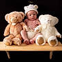 baby, infant, teddy_bear, plush_toy, knitted_hat, wooden_shelf, black_background, cute, soft_toys, child, newborn, portrait, sitting, toy, white_bear, brown_bear, hat_with_ears, barefoot, indoors, studio_photo