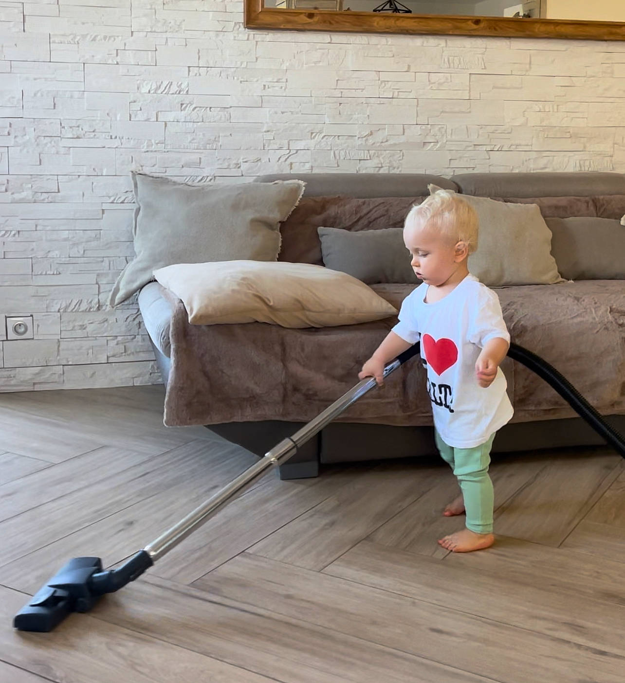 Lylio participe au concours pour gagner de l'argent avec cette photo : baby, child, cleanliness, comfort, couch, floor, flooring, hardwood, household_cleaning_supply, laminate_flooring, living_room, person, picture_frame, pillow, room, sitting, toddler, varnish, wood, wood_flooring