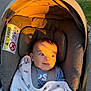 baby, bear_print, blanket, child, clothing, cushion, face, golden_hour, happy, infant, nature, outdoor, palm_trees, park, people, seat_belt, shade, stroller, sunlight, walking